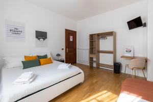 a bedroom with a large white bed and a television at Casa Orlando in Modena