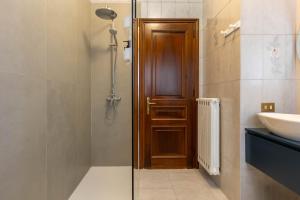 a bathroom with a shower and a wooden door at Casa Orlando in Modena +34 photos