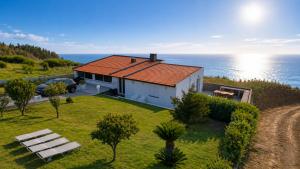 a small white house with a view of the ocean at Quintinha das Achadas in Achadas da Cruz