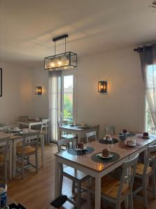a dining room with tables and chairs and a window at Hôtel du Commerce - Centre Millau in Millau