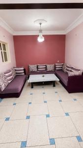a living room with purple couches and a table at Appt Spacieux, Confortable, Calme, et Lumineux, Proche de la Plage avc Fibre Optique in Safi