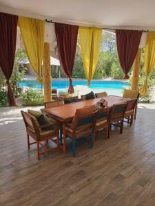 a dining room with a table and chairs and a pool at Villa Symphonie Saly in Saly Portudal +3 photos