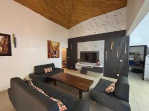 a living room with two couches and a table at Villa Symphonie Saly in Saly Portudal