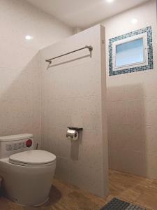 a bathroom with a white toilet and a window at Elevated Bungalow House 3-11 in Nathon Bay