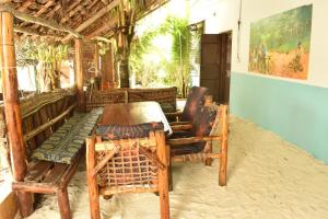 a room with a table and chairs in a building at Bamboo Garden B&B in Kendwa