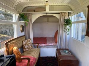 a small room with a couch and a bed in a trailer at Sky Ballonvaarten & Accommodaties in Tilburg