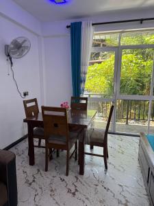 a dining room with a table and chairs and a window at Bhanuka Hevan Place in Ella