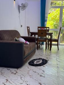 a living room with a couch and a table and chairs at Bhanuka Hevan Place in Ella