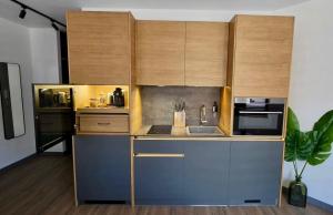 a kitchen with wooden cabinets with a sink and a microwave at Oblivion in Velingrad