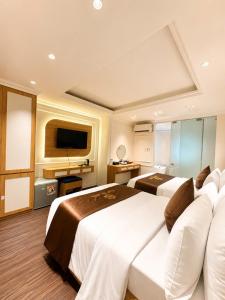 a hotel room with two beds and a flat screen tv at Giang Son Hanoi Hotel in Hanoi