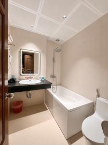 a bathroom with a tub and a sink and a toilet at Giang Son Hanoi Hotel in Hanoi +31 photos