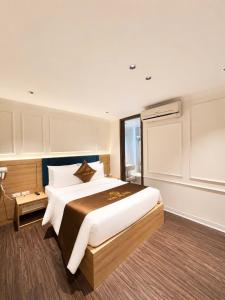 a bedroom with a large bed and a window at Giang Son Hanoi Hotel in Hanoi