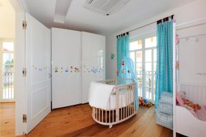 a nursery with a crib in a room with white walls at Luxury Beachfront Villa Smague with Sauna, Zadar in Diklo