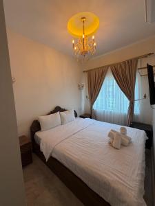 a bedroom with a large white bed with a chandelier at Mardin Kent Suit Hotel in Mardin