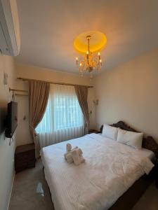 a teddy bear sitting on a bed in a bedroom at Mardin Kent Suit Hotel in Mardin +20 photos