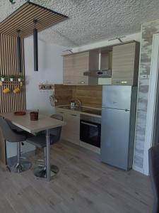 a kitchen with a table and a white refrigerator at margue residence meledrio in Folgarida