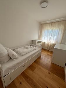 a white bedroom with a bed and a window at Hygge in Neumünster