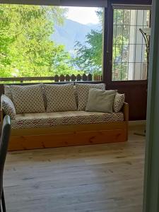 a couch in a room with a large window at margue residence meledrio in Folgarida +15 photos