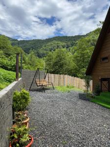a patio with a swing and a fence at Makhuntseti Inn in Makhunts'et'i