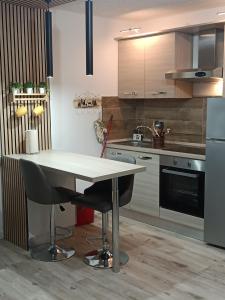 a kitchen with a white table and two chairs at margue residence meledrio in Folgarida