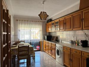 a kitchen with wooden cabinets and a table and a dishwasher at Brisa do Mar in Vagos