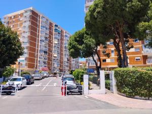 a parking lot with cars parked in front of a building at Luis Vives in Benalmádena