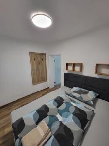a bedroom with a bed with a black and white comforter at Apartment Karin in Langenwang