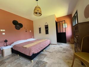 a bedroom with a bed with orange walls at Maquis in Mialet