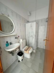 a bathroom with a toilet and a sink and a mirror at Seaside Stay Makrygialos in Makrygialos +64 photos