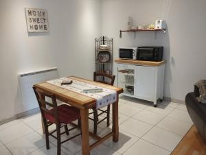 a table and chairs in a kitchen with a microwave at La Grange du Layon in Saint-Georges-sur-Layon