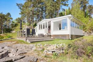 a white tiny house on a hill with trees at Sea View cottage with 2 sleeping cabins in Uddevalla