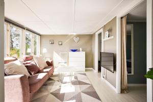 a living room with a couch and a table at Sea View cottage with 2 sleeping cabins in Uddevalla