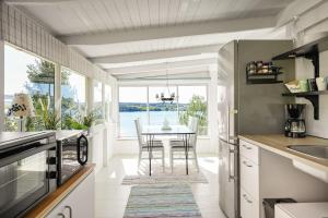 a kitchen with a table with chairs and a window at Sea View cottage with 2 sleeping cabins in Uddevalla