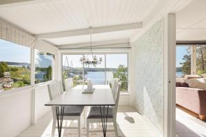 a dining room with a table and views of the ocean at Sea View cottage with 2 sleeping cabins in Uddevalla +14 photos