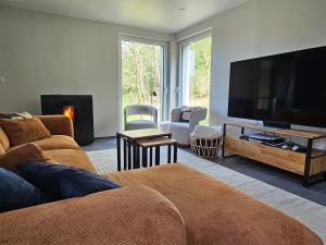 a living room with a large flat screen tv at Modern Spacious Forest Home in Aywaille