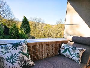 a balcony with two pillows and a window with a view at Modern Spacious Forest Home in Aywaille