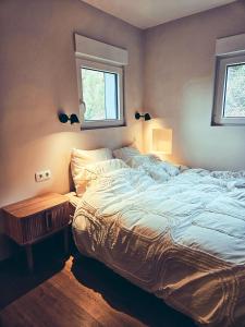 a bedroom with a large bed and a window at Modern Spacious Forest Home in Aywaille