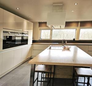 a kitchen with a large wooden table and some windows at Modern Spacious Forest Home in Aywaille