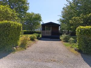 a small kiosk in a garden with a walkway at Bungalow tonga in Moncetz-lʼAbbaye