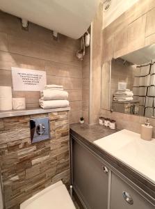 a bathroom with a sink and a toilet and a mirror at Studio cosy climatisé vue sur port in Cap d'Agde
