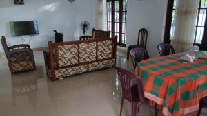 a dining room with a table and chairs and a tv at Muthu Villa in Negombo
