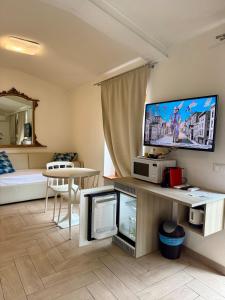 a living room with a large tv and a bedroom at Casa Cavour Garda in Garda