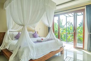 a bedroom with a canopy bed and a large window at D'nala Villa - 4 bedroom villa in Lebih