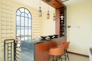 a kitchen with a bar with orange stools at D'nala Villa - 4 bedroom villa in Lebih