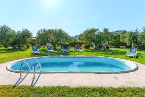 a swimming pool in a yard with lounge chairs and ayers at Residence con piscina Piricone in Orosei