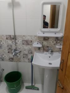 a bathroom with a sink and a mirror at Dream suits in Lower Topa