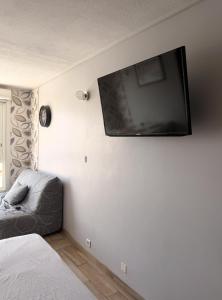 a bedroom with a flat screen tv on the wall at Studio cosy climatisé vue sur port in Cap d'Agde