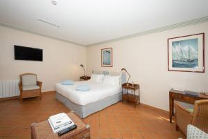 a bedroom with a bed and a table and a tv at hôtel Sube in Saint-Tropez