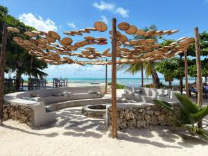 a seating area on the beach under an umbrella at Lõst Soles Lodge in Jambiani