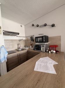 a kitchen with a wooden counter top with a sink and microwave at Studio cosy climatisé vue sur port in Cap d'Agde +4 photos
